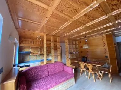 a living room with a pink couch and a table at Casa Doleda in Alba di Canazei