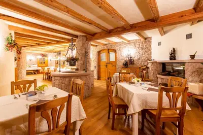 a dining room with tables and chairs and a fireplace at Appartamento Le Colonne - Relais Villa Quercia in Tassullo