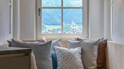 a room with a couch with pillows and a window at Castell Matscher in Bressanone