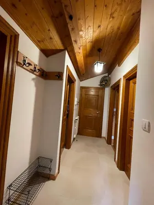 a hallway with wooden ceilings and wooden doors at Attico Vista Tofane in Cortina dʼAmpezzo