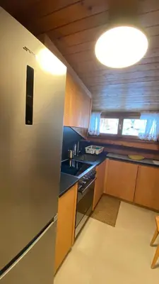 a kitchen with a stainless steel refrigerator and a sink at Attico Vista Tofane in Cortina dʼAmpezzo