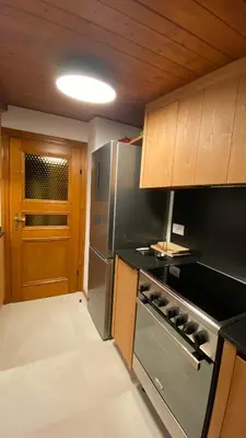 a kitchen with a stove and a refrigerator at Attico Vista Tofane in Cortina dʼAmpezzo