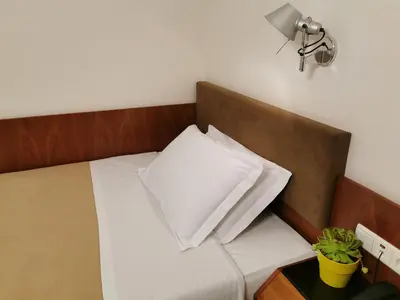 a bed with a white pillow in a room at Hotel Adria in Bolzano