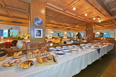 a buffet line with many different types of bread and pastries at Hotel Ranuimüllerhof in Villnoss