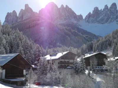 a hotel in the mountains with snow on the ground at Hotel Ranuimüllerhof in Villnoss