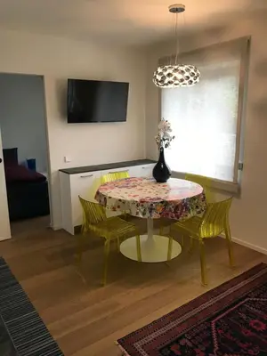 a dining room table with chairs and a vase on it at Casa sciliar blu centro paese in Fiè