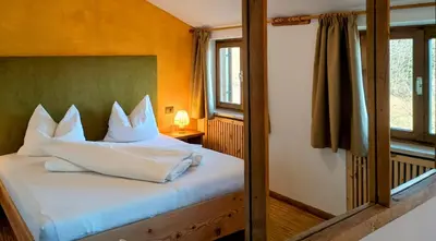 a bedroom with a bed with white pillows at Koflhof Urlaub auf dem Bauernhof in Aldino