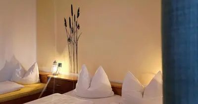 a bedroom with two beds with white pillows and a vase at Koflhof Urlaub auf dem Bauernhof in Aldino