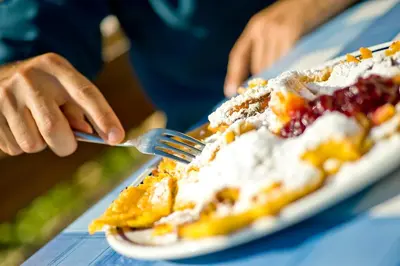 a person eating a piece of cake with a fork at Koflhof Urlaub auf dem Bauernhof in Aldino