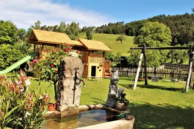 a fountain in a yard with a house in the background at Koflhof Urlaub auf dem Bauernhof in Aldino