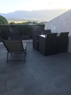 a patio with chairs and tables on a roof at Apartment Mathilda in Bolzano