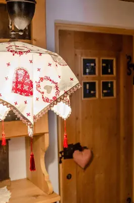 a red and white umbrella in front of a door at Casa Soraya in Falcade