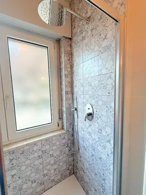 a shower with a glass door and a window at Bozen - voll ausgestattet, optimale Lage in Bolzano