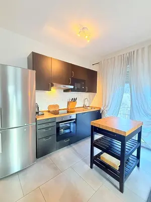 a kitchen with stainless steel appliances and a wooden table at Bozen - voll ausgestattet, optimale Lage in Bolzano