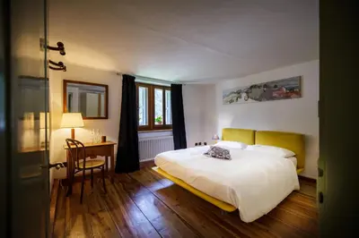 a bedroom with a bed and a table and a chair at LA PITA AGORDINA in Cancellade