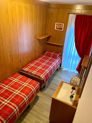 a room with two beds and a table in it at Villa Tisot in Fiera di Primiero
