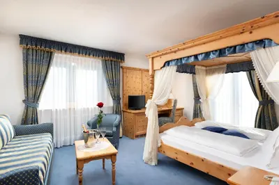 a hotel room with a bed and a couch at Hotel Gries in Canazei