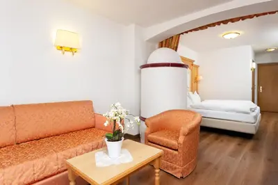 a living room with a couch and a chair at Hotel Gries in Canazei