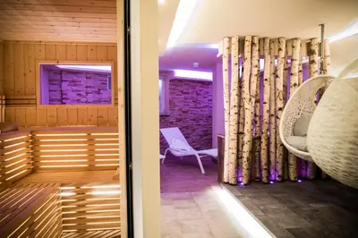 a room with a bench and a chair and a window at Hotel Gries in Canazei