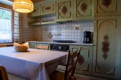 a kitchen with a table and a stove at Apartments Ciasa Colz in La Villa