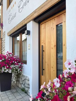 a door to a building with flowers in front of it at Apartments Ciasa Colz in La Villa