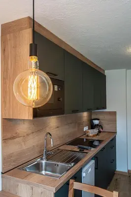 a kitchen with a sink and a pendant light at Apartments Ciasa Colz in La Villa