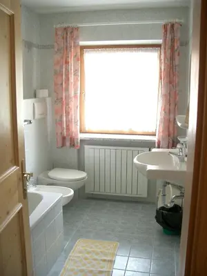 a bathroom with a sink and a toilet and a window at Apartments Sotbosch in La Villa
