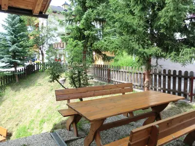 a wooden bench sitting next to a fence at Apartments Sotbosch in La Villa