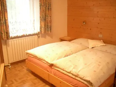 a bedroom with a bed with a wooden wall at Apartments Sotbosch in La Villa