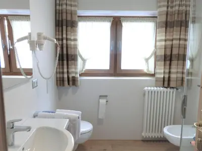a bathroom with a sink and a toilet and windows at Apartments Sotbosch in La Villa