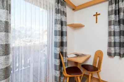 a room with a table and two chairs and a window at Apartments Puntin in San Cassiano