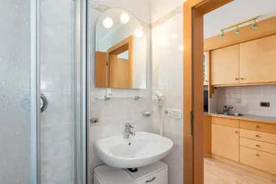 a bathroom with a sink and a shower at Apartments Puntin in San Cassiano