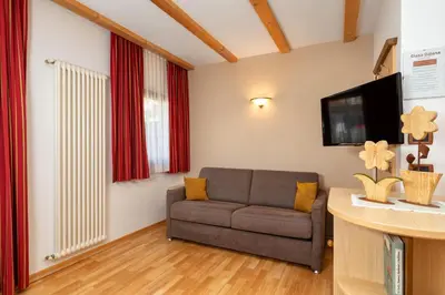 a living room with a couch and a tv at Ciasa Odlana in San Cassiano