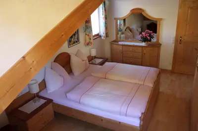 a bedroom with a bed and a staircase with a mirror at Weingut Eberlehof in Bolzano