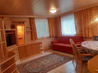 a living room with a red couch and a table at Alpen Ferienwohnung Ill in Lappago
