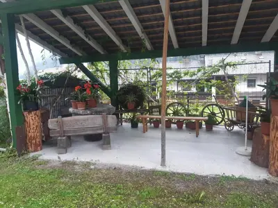 a picnic shelter with benches and potted plants at Alpen Ferienwohnung Ill in Lappago