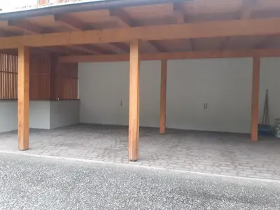 a garage with two white doors and wooden posts at Alpen Ferienwohnung Ill in Lappago