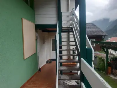 a staircase leading up to a building with a green wall at Alpen Ferienwohnung Ill in Lappago