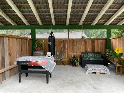 a covered patio with a table and a chair at Alpen Ferienwohnung Ill in Lappago