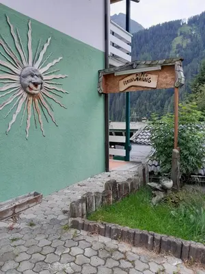 a sign in front of a building with a sun painted on it at Alpen Ferienwohnung IV in Lappago