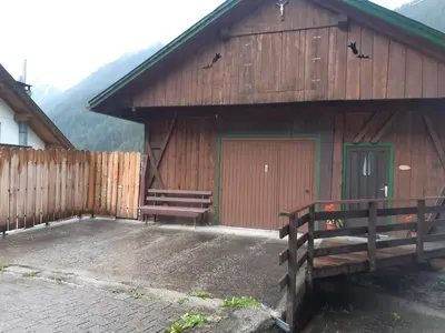 a wooden building with two benches in front of it at Alpen Ferienwohnung IV in Lappago