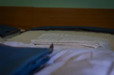 a pile of towels sitting on top of a bed at Casa per Ferie Le Rais in Pozza di Fassa
