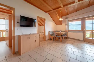 a kitchen and dining room with a table and a television at Weinhof am See in Caldaro