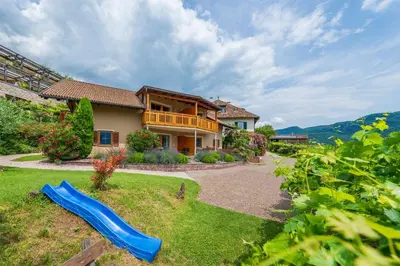 a house with a blue slide in the yard at Weinhof am See in Caldaro