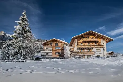 a log cabin in the snow with a christmas tree at Tlisüra in La Villa