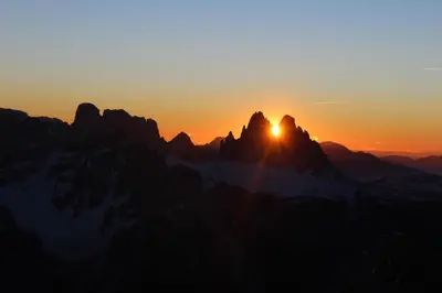 a sunset over the mountains with the sun setting at Moserhof in Marlengo