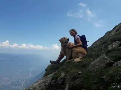 a man with a dog sitting on the side of a mountain at Moserhof in Marlengo