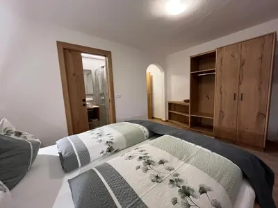a bedroom with two beds and a television in it at Moserhof in Marlengo