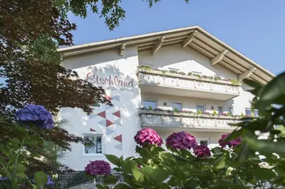 a building with flowers in front of it at Pension Etschland in Tirolo