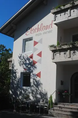 a building with a flag painted on the side of it at Pension Etschland in Tirolo